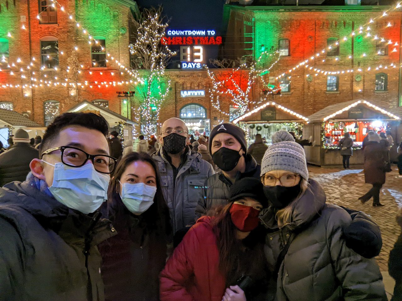 The NodeBB team posing in front of a holiday display at Toronto's Distillery District